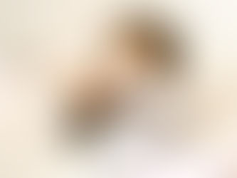 Young girl sneeze in bed, wearing a patterned pajama top. She covers her mouth with her arm, surrounded by soft pillows and blankets. Joyful Seeds Paediatric and Developmental Clinic located in Bukit Timah