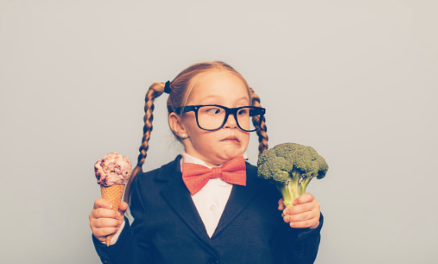 girl holding an ice cream and broccoli