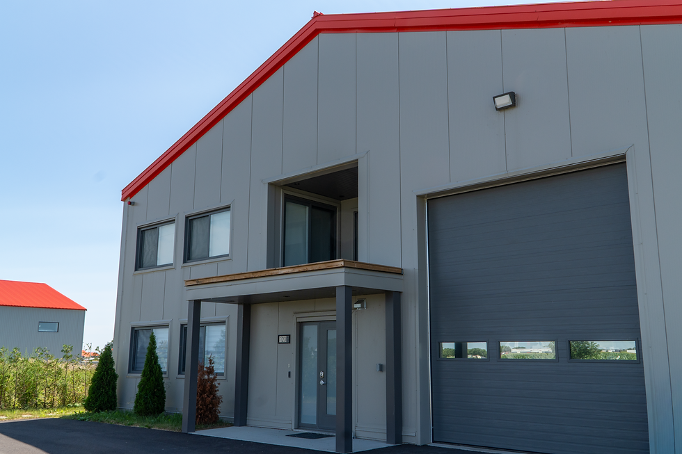 Façade d’un bâtiment industriel avec porte de garage réalisée par Construction Brault