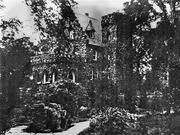 Historic photo of Oeschner's Castle. Photo is fuzzy, but shows the main castle building, a rock sculpture and paths.