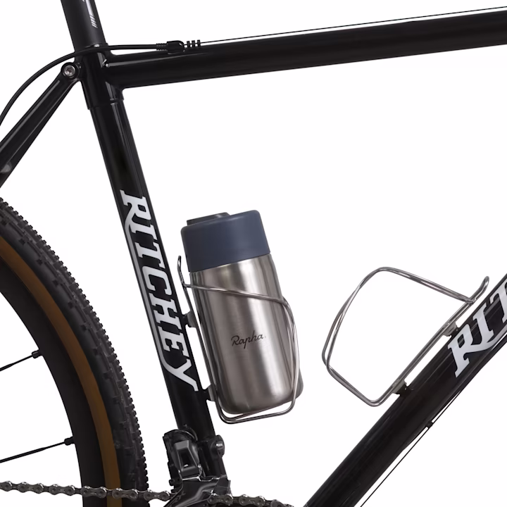 Close-up of the Black+Blum Rapha insulated coffee cup in a bike bottle cage, upright