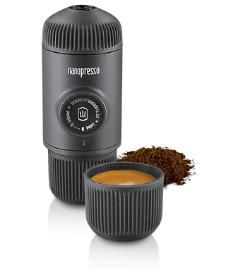 Wacaco Nanopresso espresso maker next to a shot of brewed espresso and ground coffee.