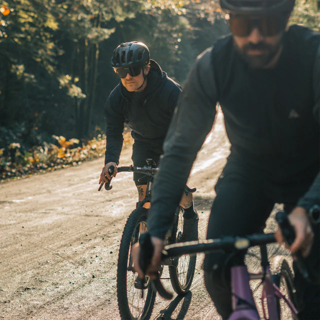 Two cyclists riding side by side on a gravel track wearing the Vallon Watchtowers cycling sunglasses