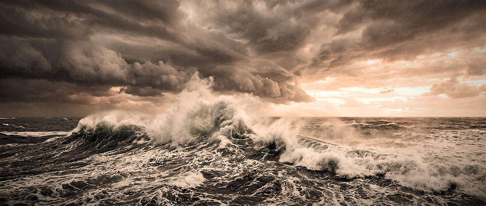 Dramatic ocean scene with a crashing wave beneath dark, turbulent storm clouds parting to reveal golden sunset light on the horizon
