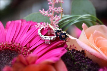 Closeup shot of two wedding rings on pink flowers