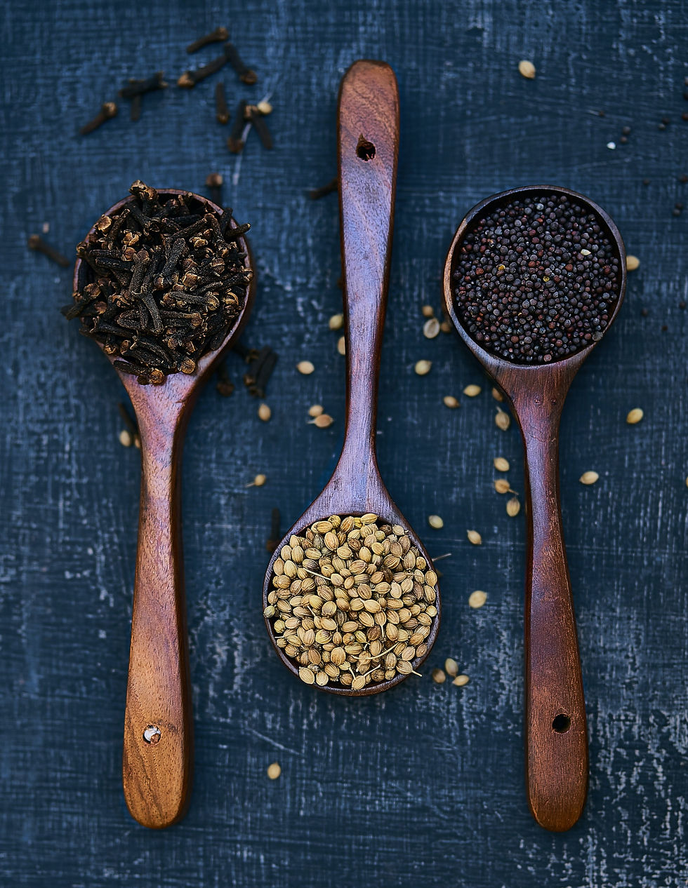 Wooden spoons with herbs, spices and botanicals