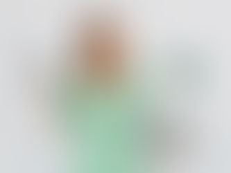 a smiling woman in a green polka dress holding a laptop balancing a green calculator