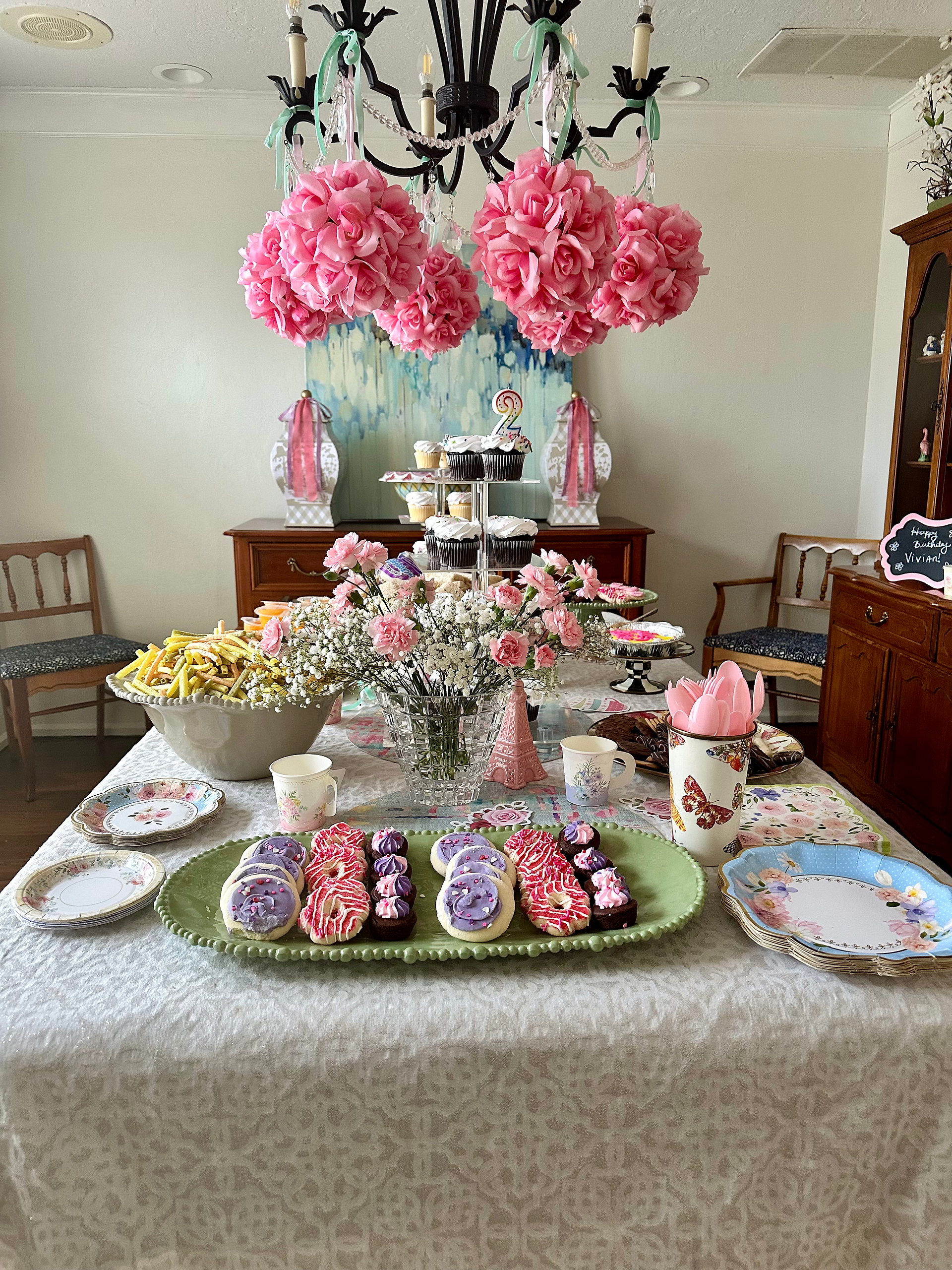 a dining room table with cookies and cakes and chips on it