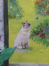 Mural painting of a ragdoll cat watching a butterfly.