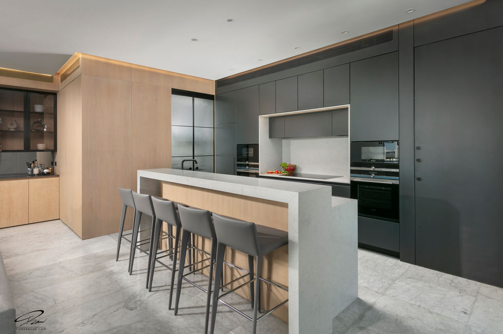 Modern kitchen with sleek design and bar stools.