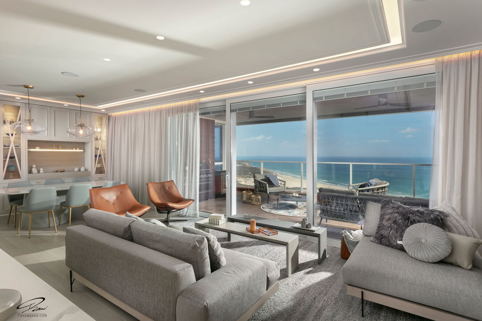 Modern living room with ocean view and stylish furniture.