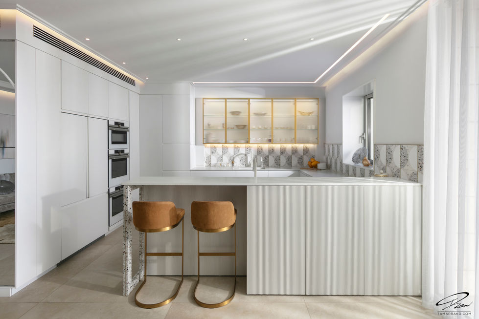 Modern kitchen with white cabinets and brown stools.