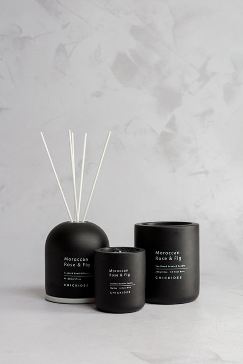 Brand photographer Simon Eldon, stylish black reed diffuser and candle against plasted background