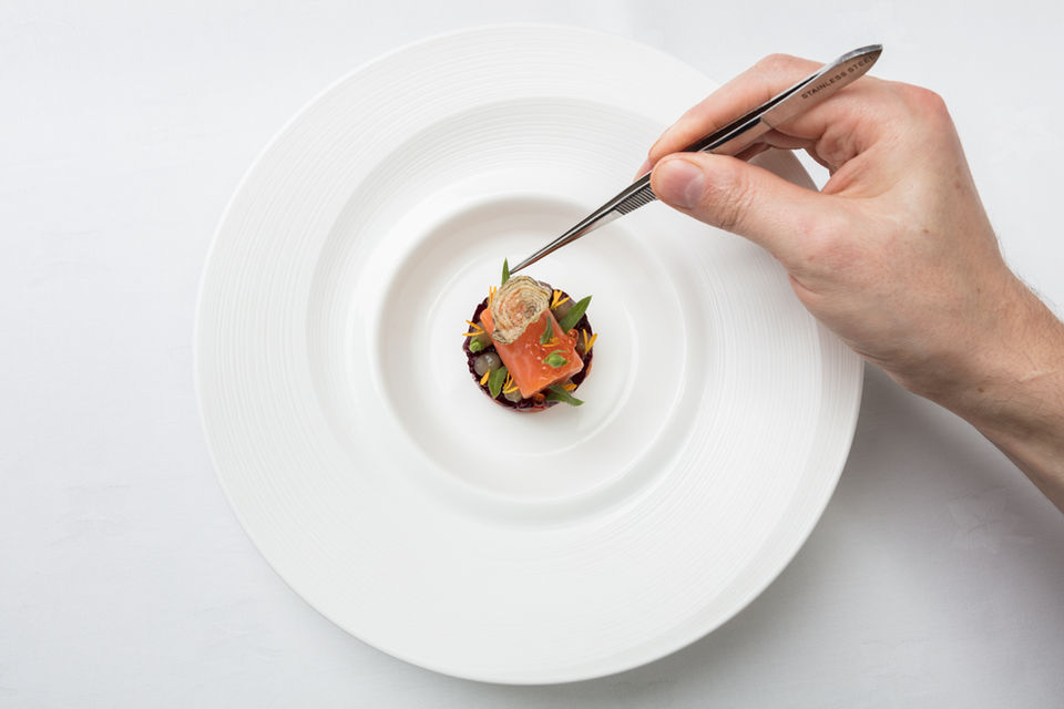 Food and Drink photography by Simon Eldon, chef arranges food on a plate at michelin star resturant