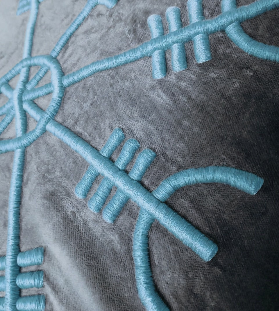 Thumbnail: Detailed macro shot of 3D lime green embroidery on textured fabric, showing the intricate stitching of a Viking symbol.