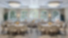 Four Seasons ballroom with crystal chandeliers and rich drapery flanking ceiling to floor windows. Round tables with cream linens and yellow florals.