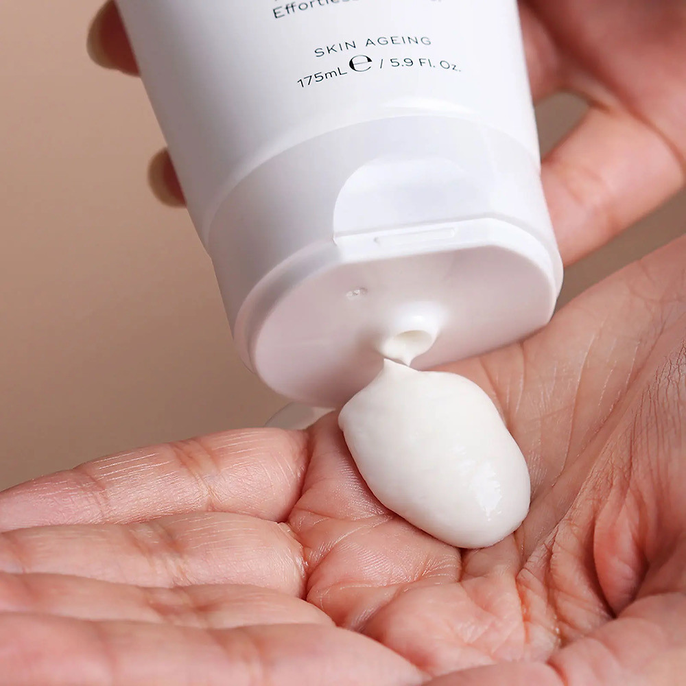 person holding Medik8 Cream Cleanse bottle