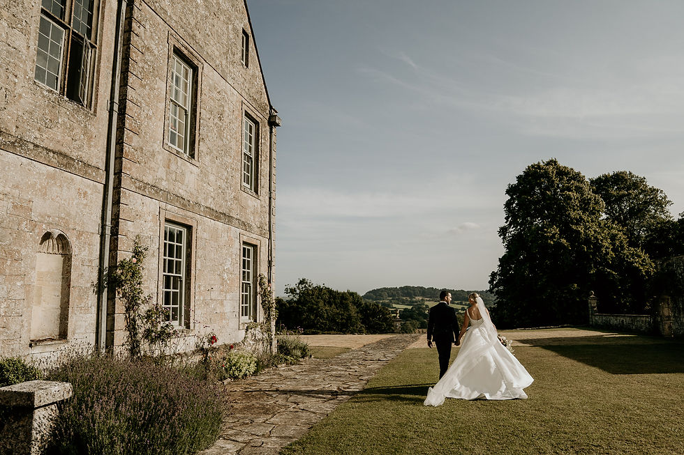 bride and groom walking away on their wedding day at Hatch House Wiltshire