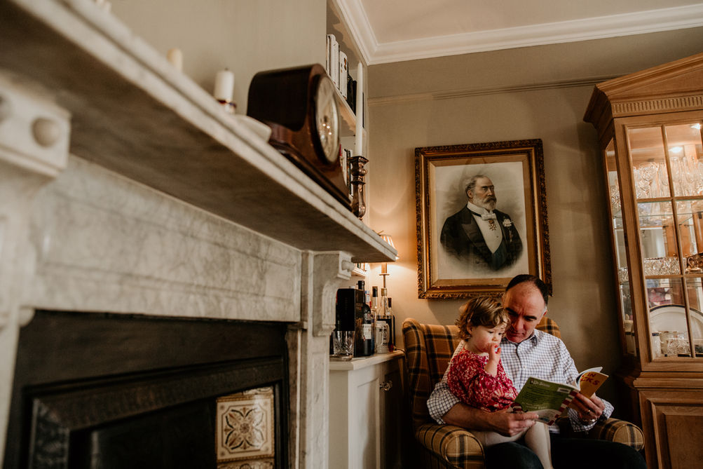 Granddad reading to his grandchild on a family photo shoot in Dorset photography by Louisa Jane 