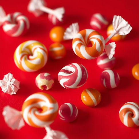candies floating around on a red background.jpg