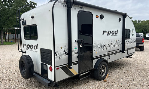 Sportsman's RV Rentals camper set up at campsite towed by SUV