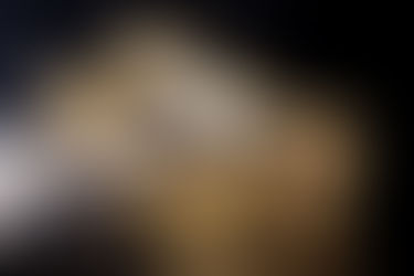 A close-up view of a key and a lock cylinder, removed from a knob to be rekeyed, showcasing their intricate metallic details.