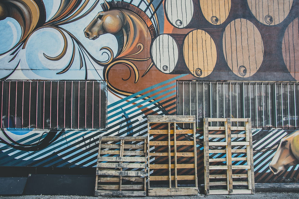 Wooden pallets next to an art wall