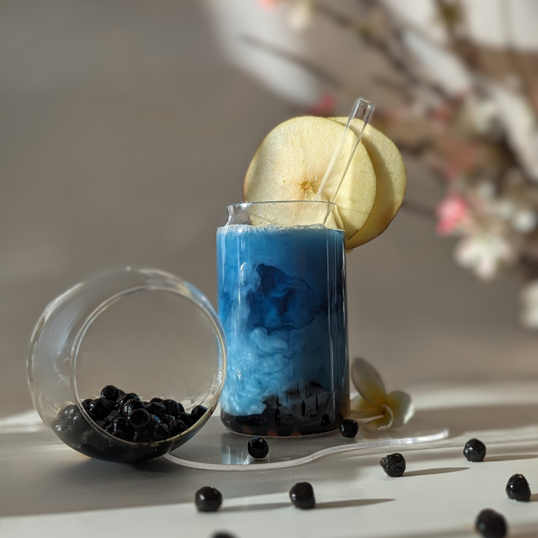 Organic butterfly pea tea boba with vibrant blue color and chewy tapioca pearls, served in a refreshing drink.