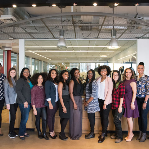 A group of women standing in an office.