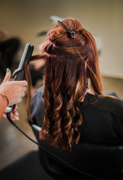 A salon stylist styles a customer's hair