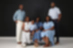 A smiling multi-generational family in blue attire.