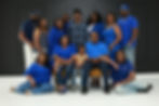 Large family in coordinated blue outfits for a group portrait.