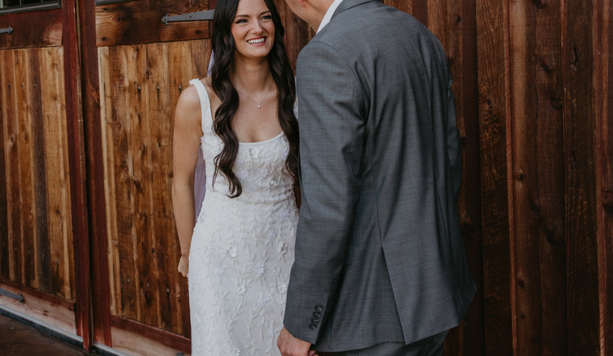 Bride and groom smiling at each other, Leah and Anthony's Summer Wedding at Sugar Pine Barn at Tucannon Cellars.