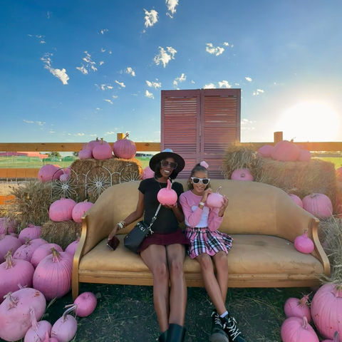 Family posing in pink pumpkin patch
