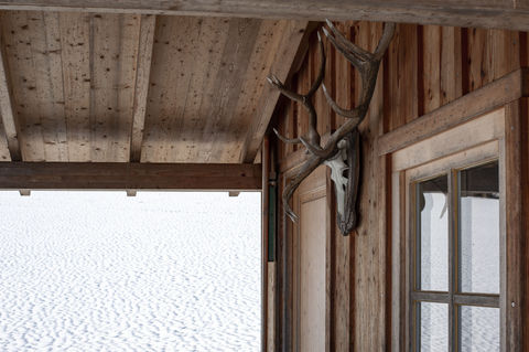 beautiful-shot-lodge-house-with-deer-antlers-hanging-window-snow-back (1).jpg