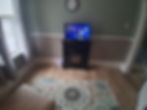 Sitting room with TV, electric fireplace, and patterned rug