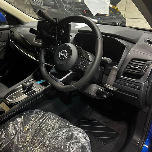 Interior shot of a mobility modified car showing custom pedal guards and electronic accelerator controls
