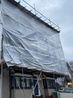 Large scaffolding structure around property with temporary roof