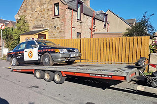 Police car on the back of recovery truck