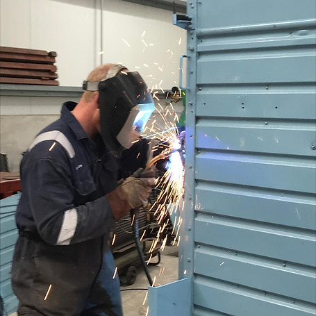 Welder welding on steel door