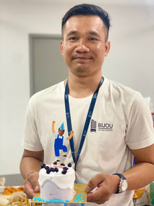 BIJOU employee holding his birthday cake