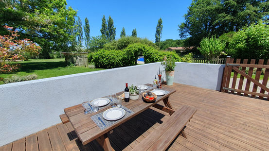 Terrasse en bois du Domaine du Bardon, gîte avec mobilier d’extérieur pour des repas en plein air. Location vacances avec jardin privatif et espaces détente en Charentes-Maritimes.