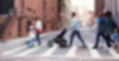 diverse group of adults and children cross city street