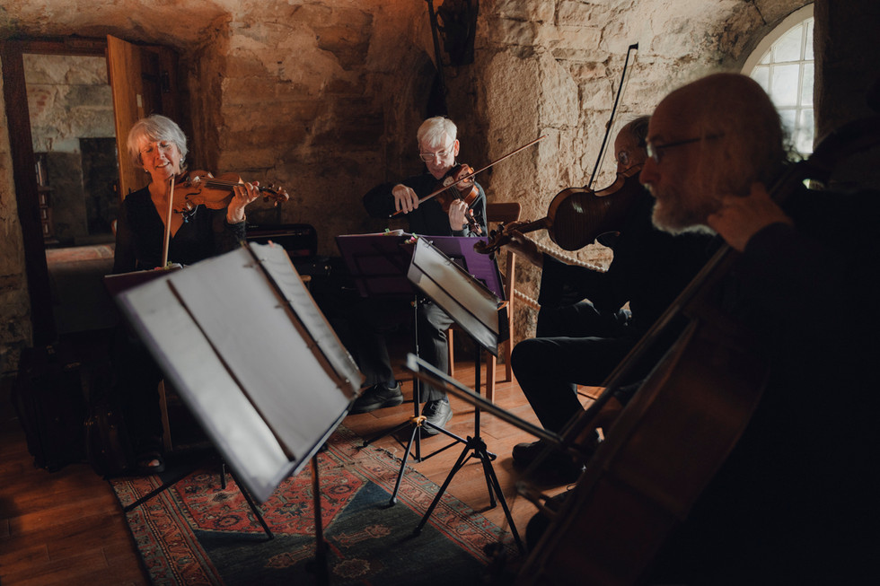 Emotional ceremony inside the Auld Keep at Dundas Castle, with stone walls and romantic candlelight atmosphere. persian & Jewist ceremony. string quatert