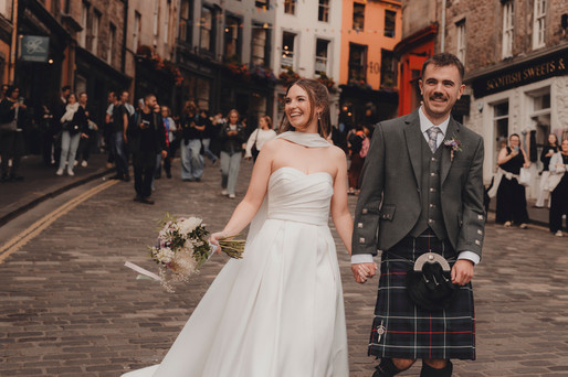 Wedding couple enjoying Victoria Street in Edinburgh, editorial-style candid portraits.