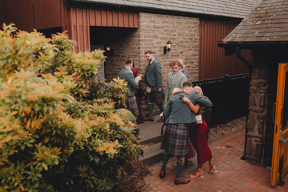 Groom with groomsmen greeting guests before ceremony at Forbes of Kingennie