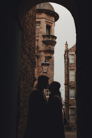 Cinematic romantic couple session in Edinburgh during Christmas, set among the historic Old Town and Calton Hill with festive winter atmosphere.