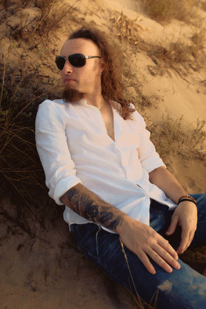 Professional beach photoshoot of a musician, artistic portrait with natural light for music promotion and personal branding.