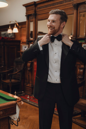 Bagpiper and cultural elements during groom preparation in Scottish castle wedding photography