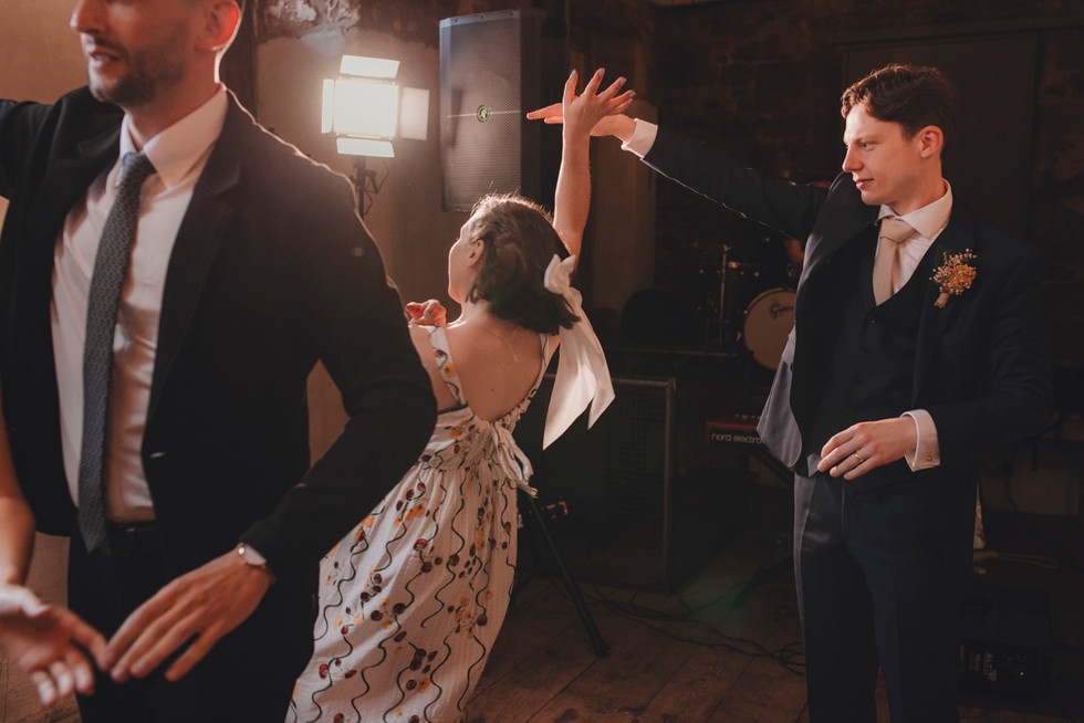 Guests dancing a traditional ceilidh at The Free Company, Balerno – fun and real Scotland wedding photography.
